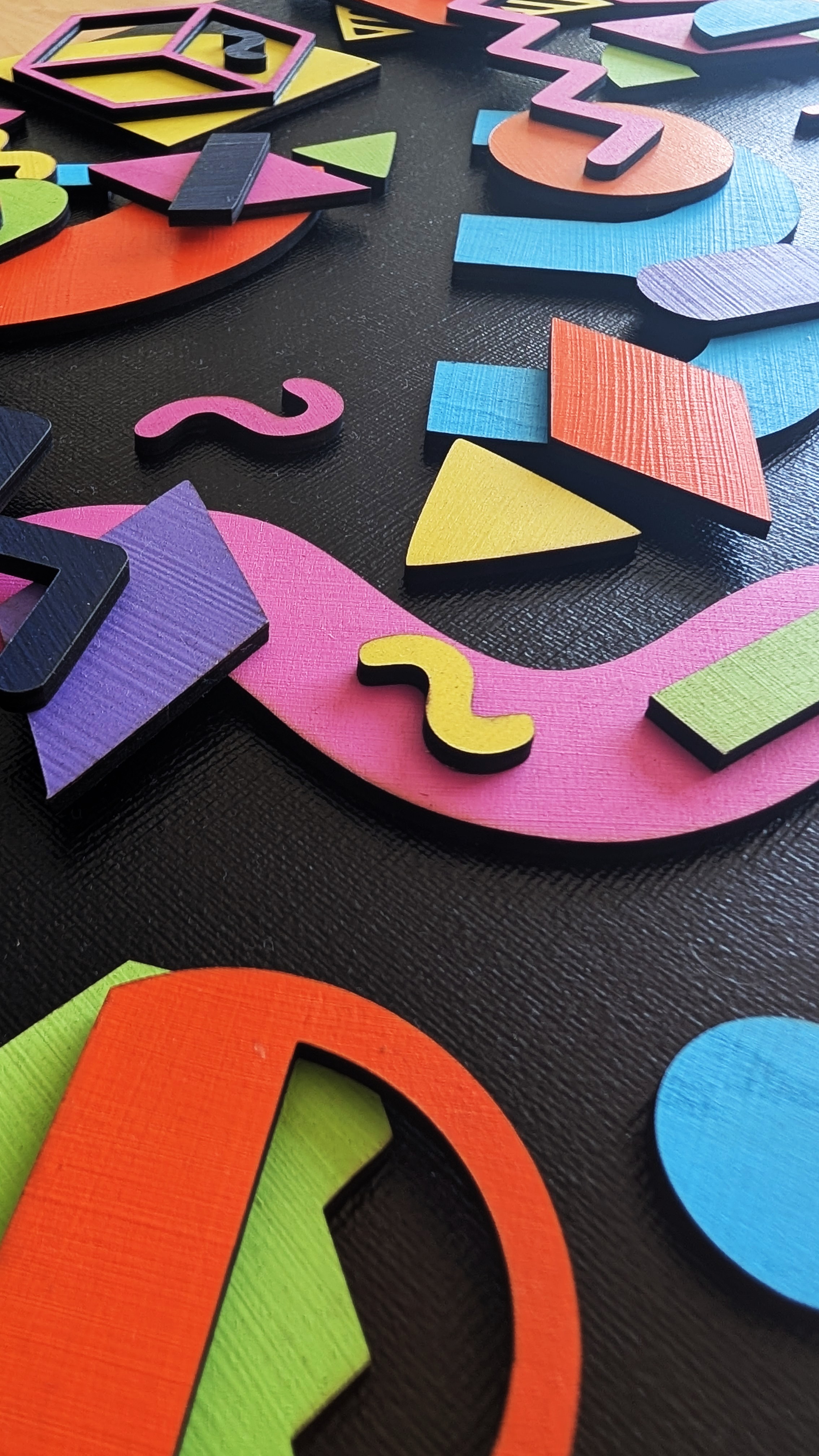 Formes géométriques colorées en bois relief sur toile noire, style Memphis Design